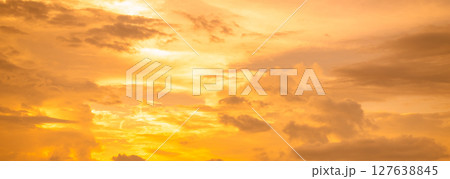 Golden sky texture background during sunset creating warm gradient colors perfect for luxury brand marketing and romantic design projects requiring elegant atmospheric natural lighting effects 127638845