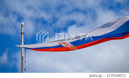 Huge Flag of Serbia flapping in the wind on a flagpole Huge Flag of Serbia flapping in the wind on a flagpole 127639072