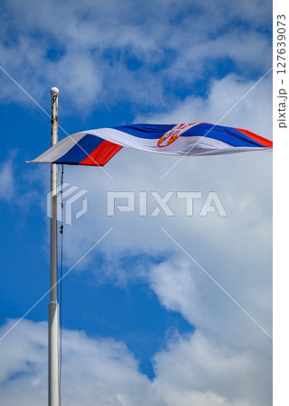 Huge Flag of Serbia flapping in the wind on a flagpole Huge Flag of Serbia flapping in the wind on a flagpole 127639073