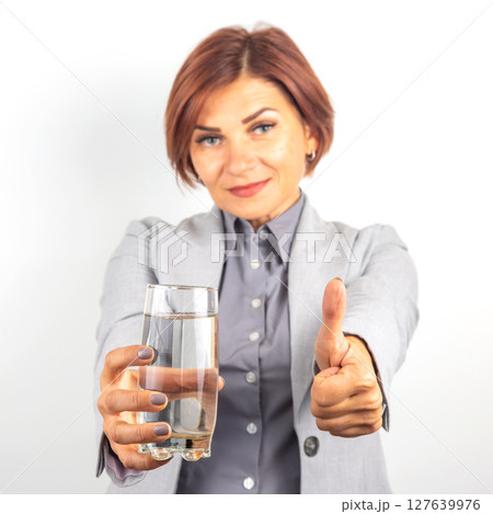 Happy beautiful business woman offers a glass of water. Thirst and health. 127639976