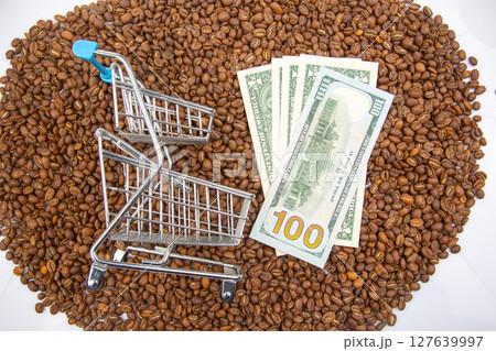 Coffee industry and finance concept with a shopping cart on coffee beans and US currency Coffee industry and finance concept with a shopping cart on coffee beans and US currency 127639997