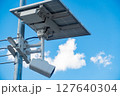 屋外に設置された太陽光パネル付きの監視カメラの写真。 127640304