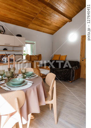 Cozy Rustic Cabin Interior with Dining Setting, Plush Sofa, and Warm Lighting: A Stylish Woodsy Retreat in Earth Tones 127640451