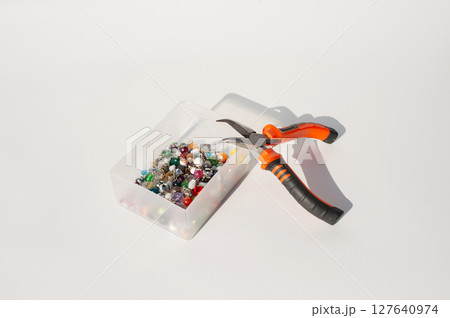 Craft beads and pliers on table for jewelry making 127640974