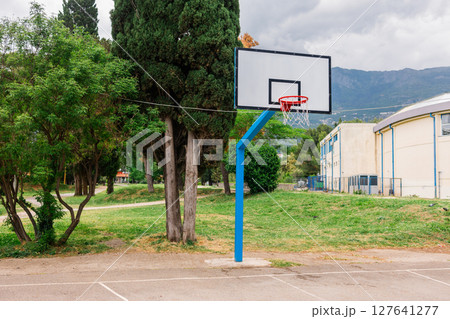 Outdoor basketball hoop in a public park. Urban recreation, sports activity, and healthy lifestyle in a community setting. 127641277