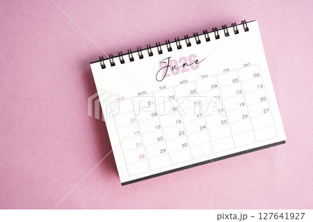 Top view of June 2026 desk calendar on pink pastel background. 127641927