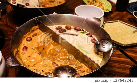 Chinese or Taiwanese hot pot with two different soup including spicy soup and a tofu (bean curd) milky soup Chinese or Taiwanese hot pot with two different soup including spicy soup and a tofu (bean curd) milky soup 127642243