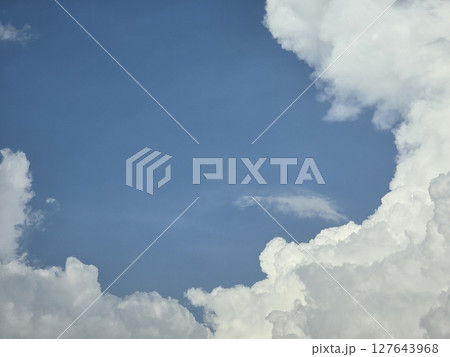 Fluffy white clouds against bright blue sky create serene atmosphere, inviting relaxation and contemplation. contrast of colors enhances beauty of nature Fluffy white clouds against bright blue sky create serene atmosphere, inviting relaxation and contemplation. contrast of colors enhances beauty of nature 127643968