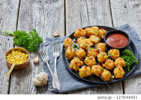 corn nuggets on a plate with tomato sauce 127644081