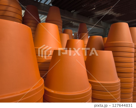 Stacks of terracotta flower pots filling a warehouse 127644831