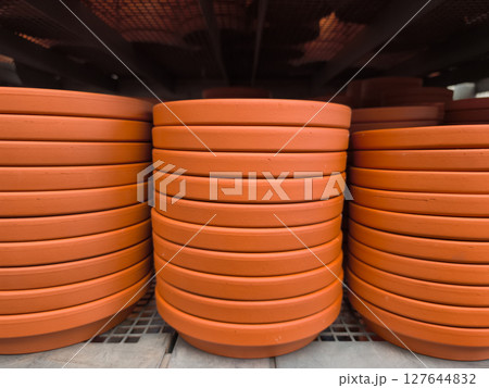 Stacks of terracotta plant trays waiting in a garden center 127644832