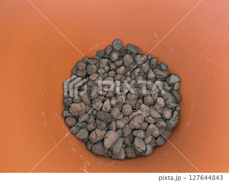 Clay pebbles filling the bottom of a terracotta pot for drainage copy space Clay pebbles filling the bottom of a terracotta pot for drainage copy space 127644843