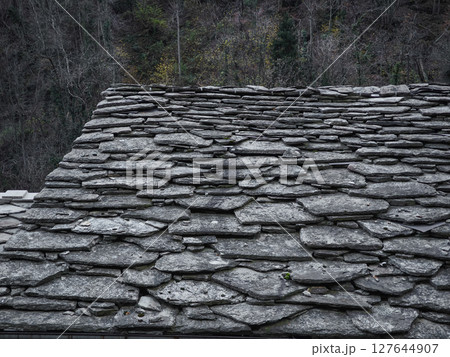 Weathered stone roof texture contrasting autumnal foliage in aosta valley, highlighting traditional mountain architectural elements pontboset Weathered stone roof texture contrasting autumnal foliage in aosta valley, highlighting traditional mountain architectural elements pontboset 127644907