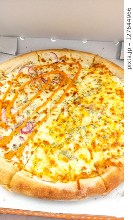 Delicious four cheese pizza with spicy sauce and red onions in cardboard box 127644966
