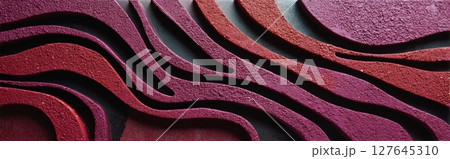 Oxblood red sculpted stone relief with wave-like texture in top view 127645310