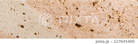 Warm beige travertine slab with natural porous texture and mineral inclusions 127645400