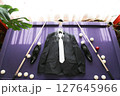 The groom's suit lies on the billiard table. 127645966
