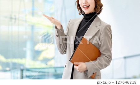 手で案内をする女性・ビジネスウーマン 127646219