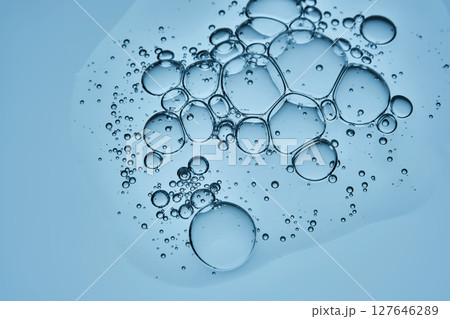 Delicious serum texture with bubbles on a blue background. Delicious serum texture with bubbles on a blue background. 127646289