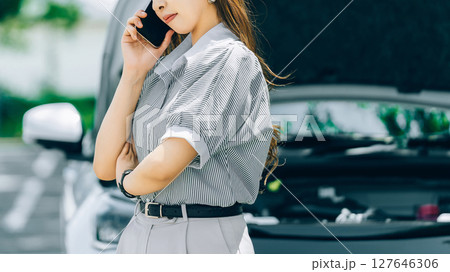 車が故障してロードサービスに連絡する女性 127646306