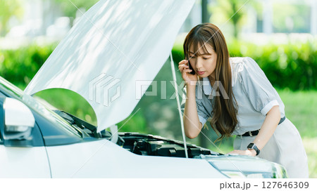車が故障してロードサービスに連絡する女性 127646309