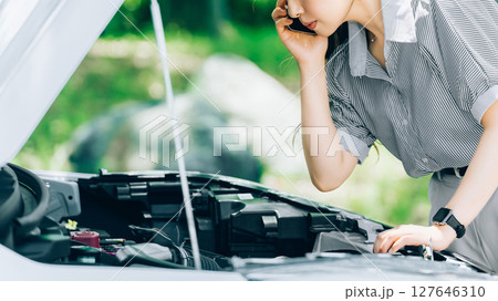 車が故障してロードサービスに連絡する女性 車が故障してロードサービスに連絡する女性 127646310