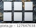 Six blank white cards arranged on textured gray rock background surface 127647638