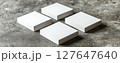 Four stacks of blank business cards on a textured surface 127647640