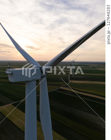 Aerial view of wind turbine on an agricultural filed at sunset. Close up of blades. Aerial view of wind turbine on an agricultural filed at sunset. Close up of blades. 127648283