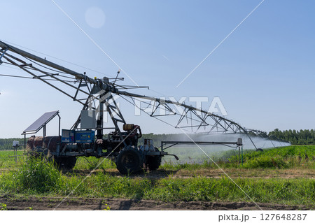 Autonomous machine is moving watering pivot along irrigation canal Autonomous machine is moving watering pivot along irrigation canal 127648287