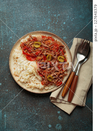Ropa vieja with white rice, tomato sauce and green olives on a plate top view, traditional dish of Cuba Ropa vieja with white rice, tomato sauce and green olives on a plate top view, traditional dish of Cuba 127648379
