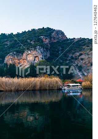 View of famous rock cut temples tombs of kings at ancient  Greek city Kaunos in Caria or Caunus in Roman period in Anatolia. Popular place for family travel on summer vacation. Dalyan, Mugla Turkey 127648462