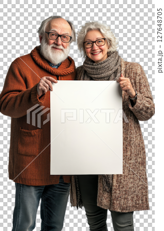 Elderly couple joyfully holding a blank canvas while standing together indoors in soft lighting 127648705