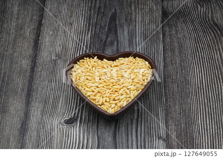 Raw fresh and healthy dry organic barley noodle on wooden spoon 127649055
