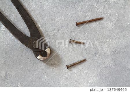 Old rusty pliers and nails on a stone background. View from above 127649466