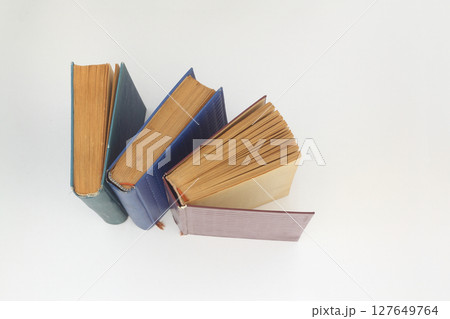 Stack of books in colour covers with white sheets isolated on a white background Stack of books in colour covers with white sheets isolated on a white background 127649764
