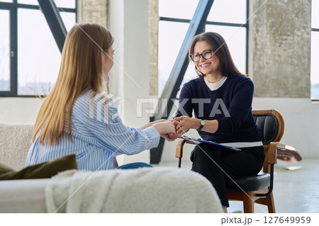 Professional female therapist counselor psychologist working with young woman patient 127649959