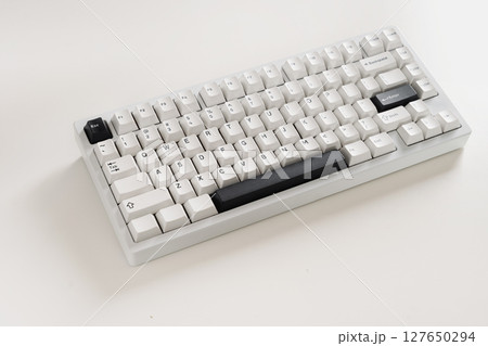 Modern mechanical keyboard on white desk as background. Minimal style and design keyboard. Custom build keyboard with black and white cap. Close up Modern mechanical keyboard on white desk as background. Minimal style and design keyboard. Custom build keyboard with black and white cap. Close up 127650294