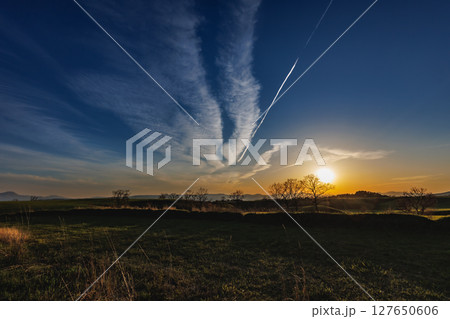 日が傾いた空に残る飛行機雲（やまなみハイウェイ） 127650606