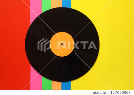 Black Vinyl record on a colorful background. Retro style. Top view. Black Vinyl record on a colorful background. Retro style. Top view. 127650868