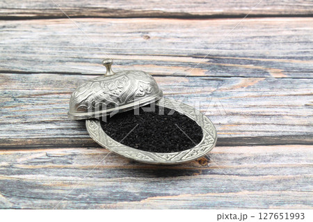 Black cumin seeds and essential oil with bowl and wooden shovel or spoon. Nigella Sativa in glass bottle. Organic herbal medicine for many diseases Black cumin seeds and essential oil with bowl and wooden shovel or spoon. Nigella Sativa in glass bottle. Organic herbal medicine for many diseases 127651993