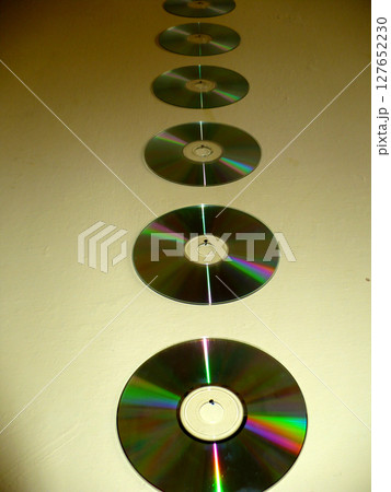 six CDs on the yellow wall reflect the light 127652230