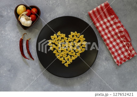 Italian Food background on stone table Top view. With heart shaped bowl Italian Food background on stone table Top view. With heart shaped bowl 127652421