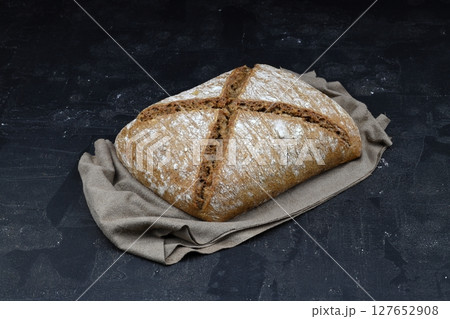 Sliced homemade sourdough rye bread with rye flour on black textured background. Top view or flat-lay. Low key Sliced homemade sourdough rye bread with rye flour on black textured background. Top view or flat-lay. Low key 127652908
