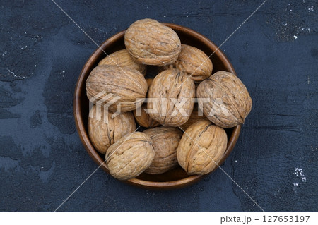 broken walnuts and nutcracker on black background 127653197