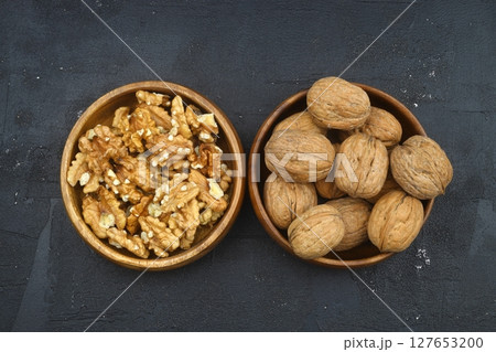 broken walnuts and nutcracker on black background 127653200