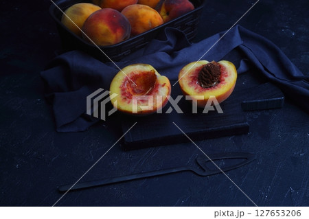 fresh juicy peaches with leaves on dark concrete background with knife fresh juicy peaches with leaves on dark concrete background with knife 127653206