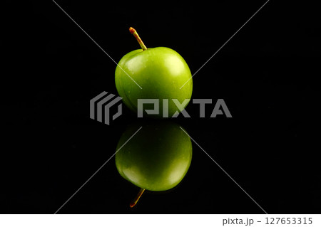 Green plums on black background Green plums on black background 127653315