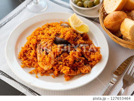 Delicious traditional Valencian seafood paella - savory rice dish with shrimps and clams Delicious traditional Valencian seafood paella - savory rice dish with shrimps and clams 127653464