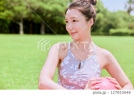 天然芝と青空の下、リゾート気分でヨガ&ピラティスをする女性 天然芝と青空の下、リゾート気分でヨガ&ピラティスをする女性 127653849